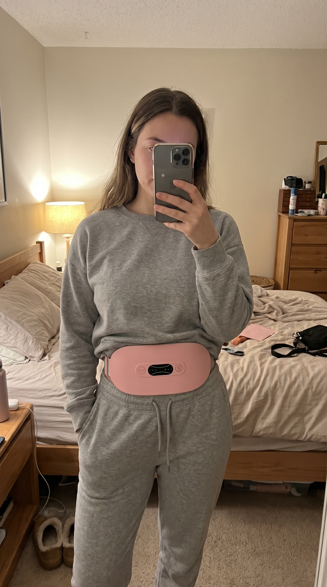 Mirror selfie wearing Enigmae Ease cramp relief belt over loungewear