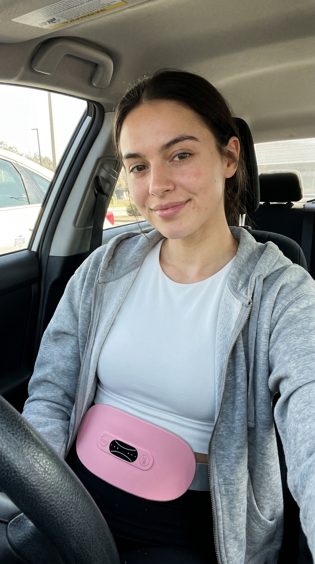 Cordless period relief belt worn under hoodie while driving