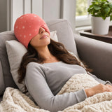 Woman relaxing on sofa wearing the migraine relief cap with eye mask down